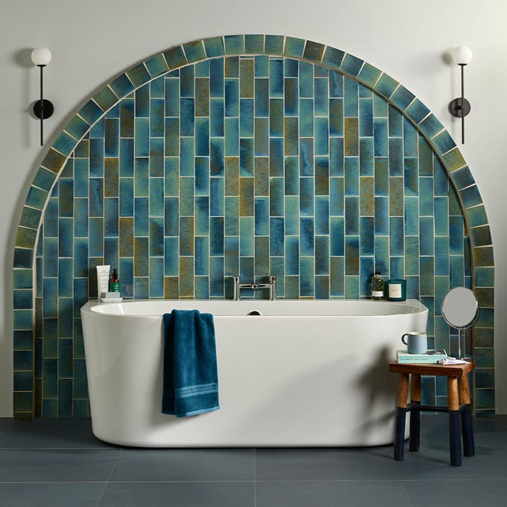 Image of Bathroom with a tiled wall behind a freestanding bathtub