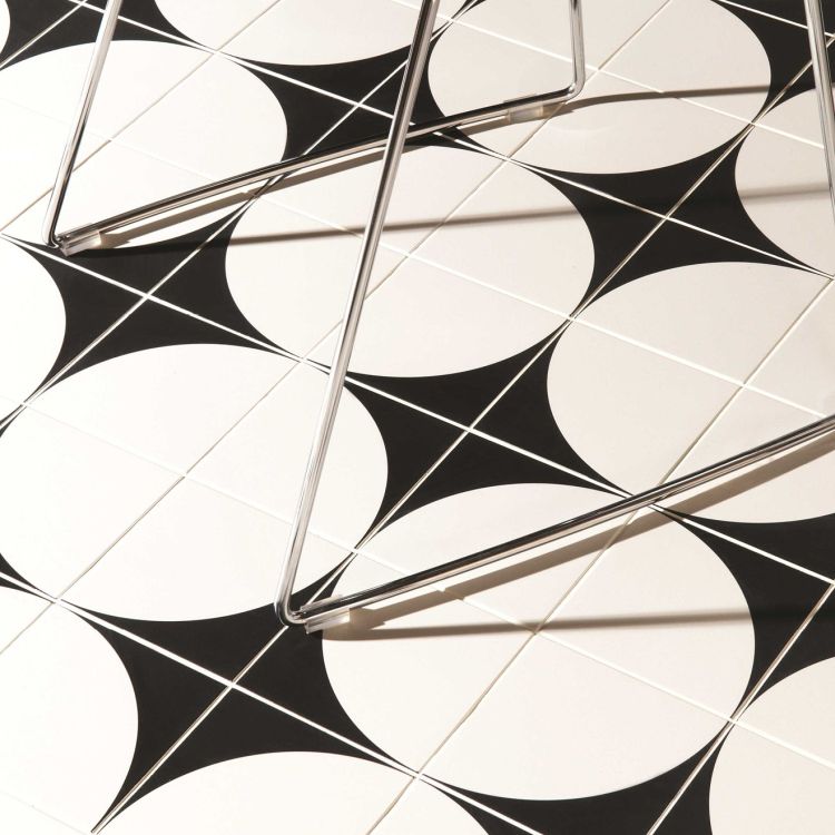 Image of Black and white geometric pattern on a tiled wall with metal brackets.