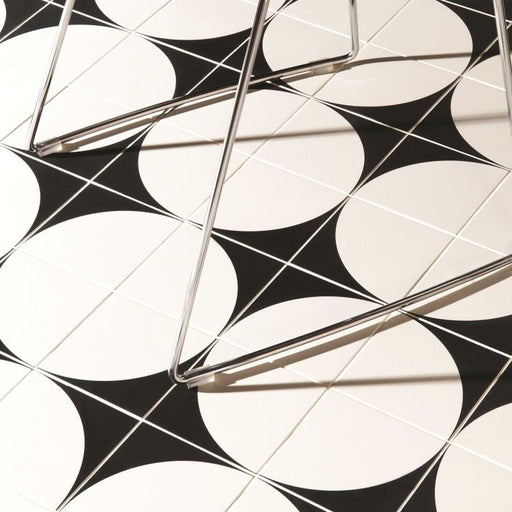 Black and white geometric pattern on a tiled wall with metal brackets.