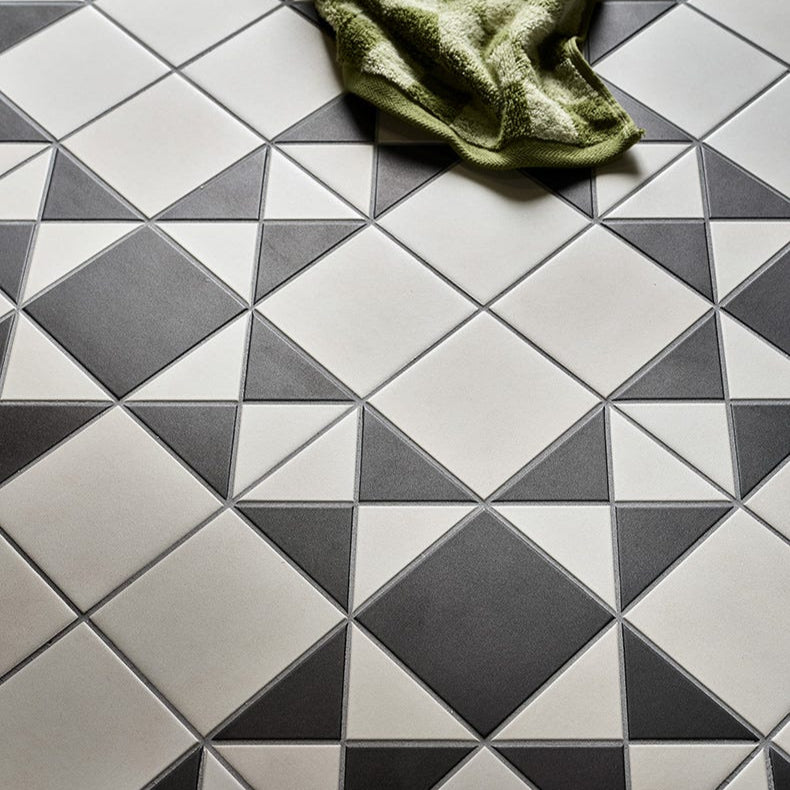 Image of Geometric tile pattern with a green towel on a tiled floor