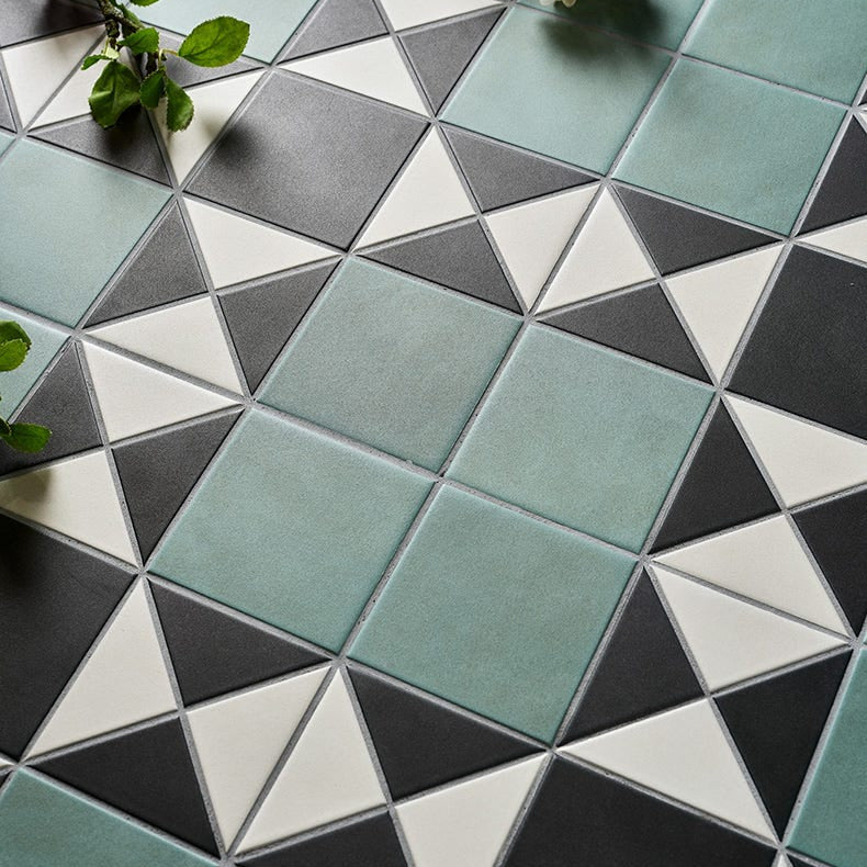 Image of Geometric pattern of triangular tiles in green, gray, and white with flowers on a surface.