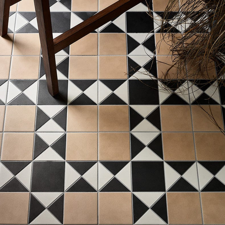 Image of Geometric tile pattern on a floor with a wooden chair leg visible