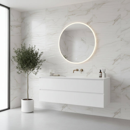 Minimalist white floating bathroom vanity with a circular LED mirror, marble-effect wave tile feature wall, and a potted indoor tree in a bright modern bathroom.