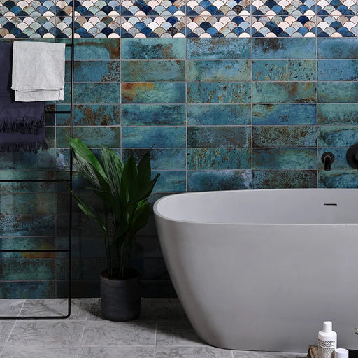 Modern bathroom with a freestanding bathtub against a colorful tiled wall.