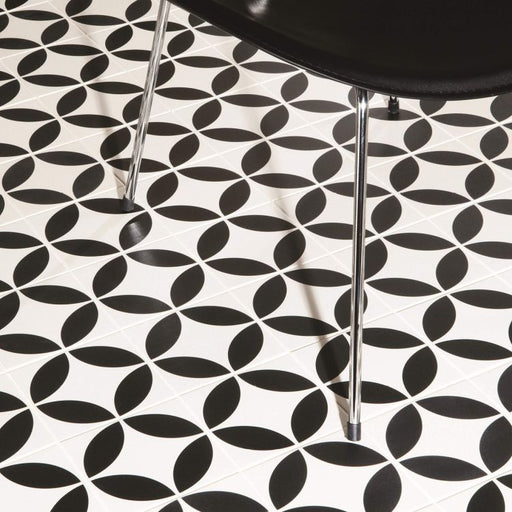 Black and white geometric patterned floor with a black chair.
