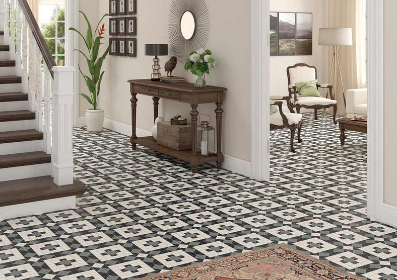 Harrogate Patterned floor tiles 31.6x31.6cm. Victorian floor tiles as hallway tiles in a period property setting. White, grand staircase with view into living room featuring Victorian style chairs and coffee table. Wooden Console table in the hallway with decorative lantern, vase and potted plant.
