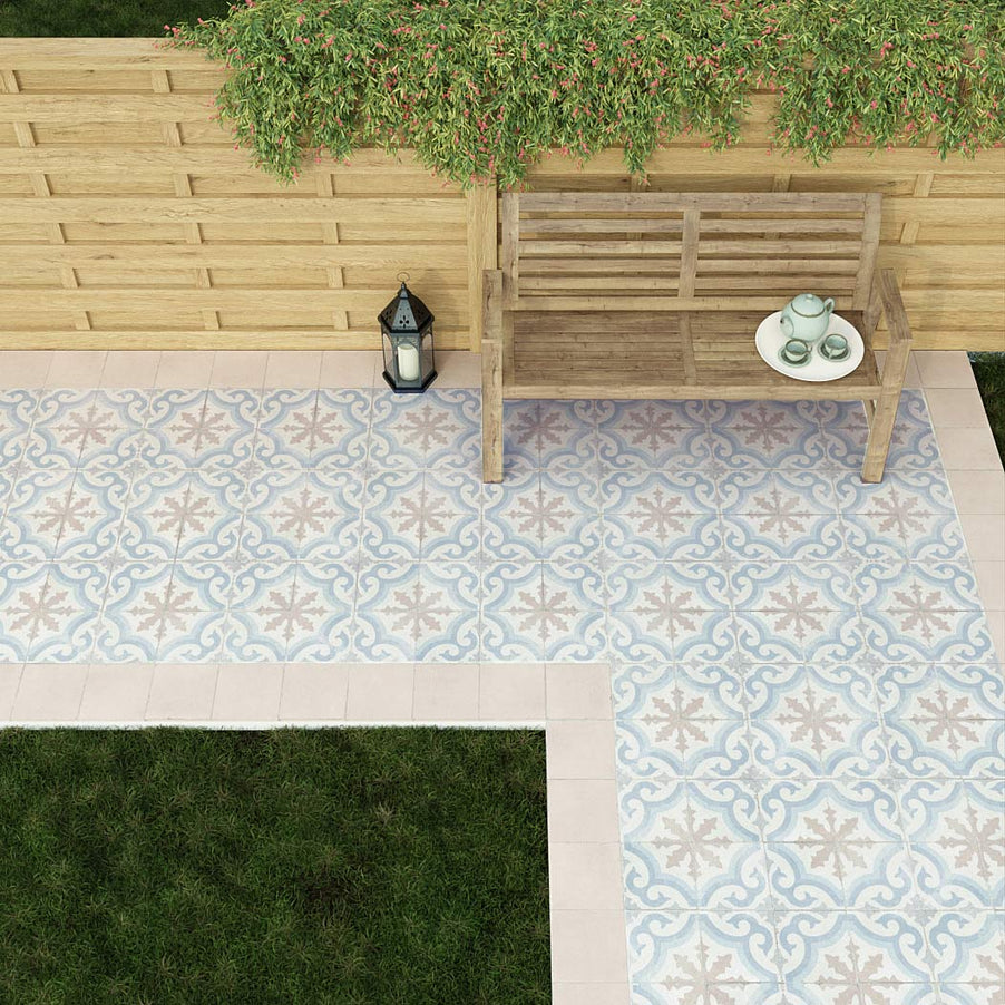Remor pattern tiles 20x20cm as a garden path. Wooden bench with tea set, lantern, wooden fencing and greenery.
